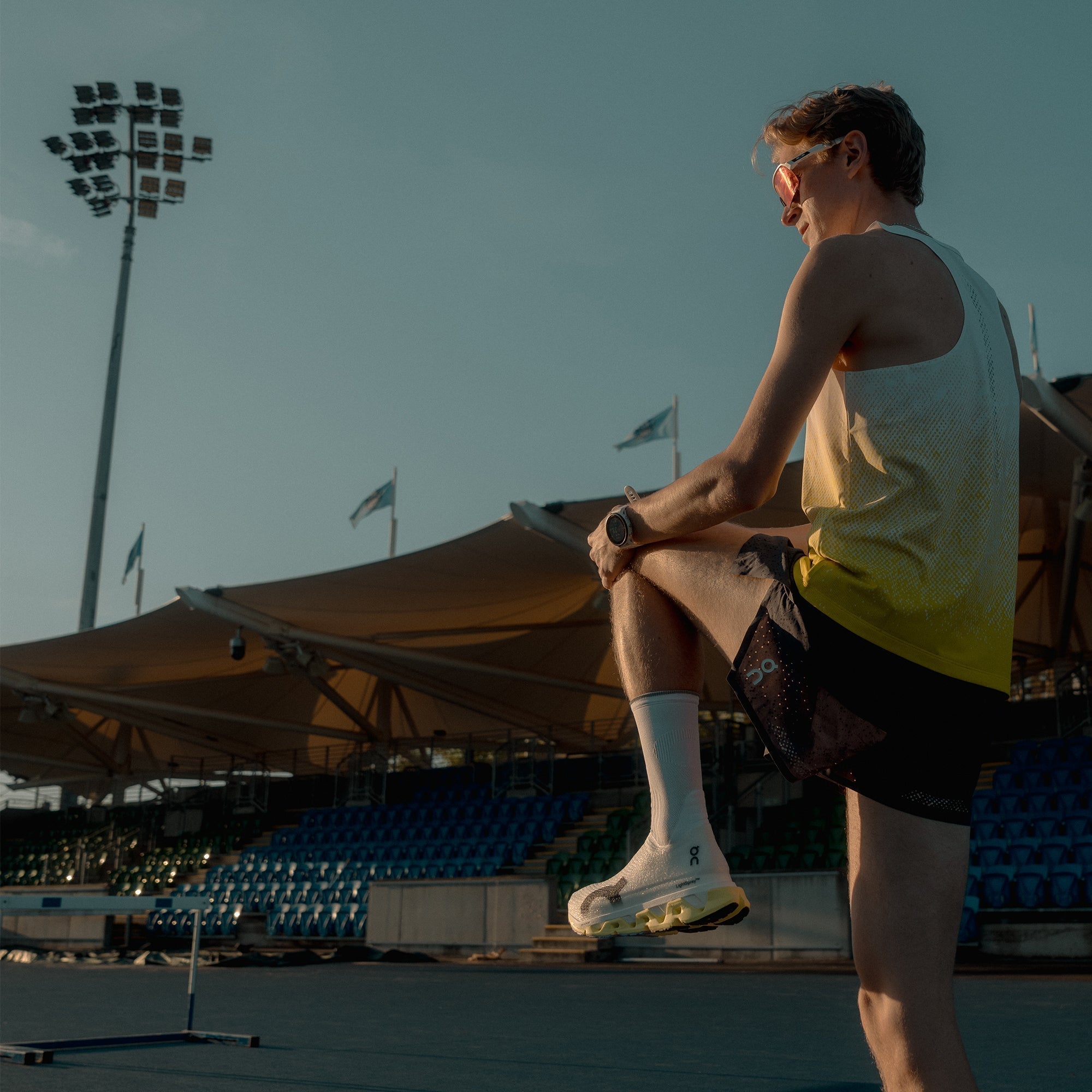 Jamie Burns stretching before run wearing On LightSpray Cloudmonster 3 Hyper running shoes