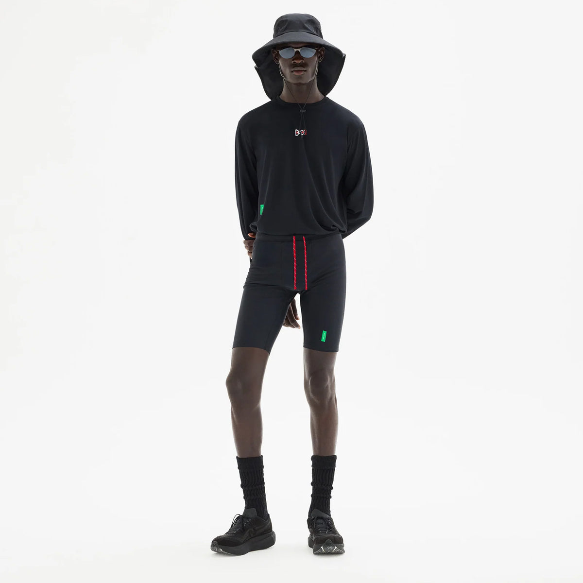 District Vision 9 Inch Recycled Half Tights Black full body view on male runner showing four-way stretch with side phone pocket featuring interior dividers and discrete waistband key pocket