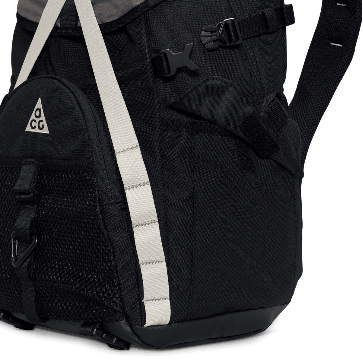 Close-up of the Nike ACG Daymax 25L Backpack in Black / College Grey, featuring white straps, a mesh front pocket, and the signature ACG triangle logo. The image highlights part of the main compartment, a buckle, and padded shoulder straps—showcasing this adventure-ready backpack’s practical design for all your outdoor needs.