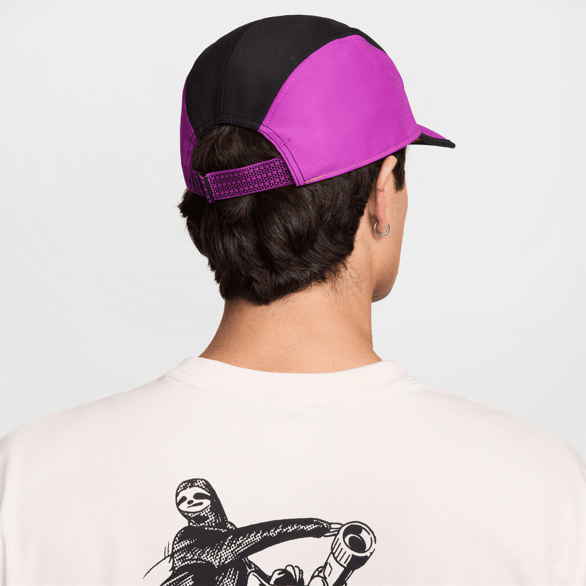 Nike ACG Fly Unstructured Cap Safety Orange Vivid Purple Black back view on model showing adjustable strap with clip and unstructured design