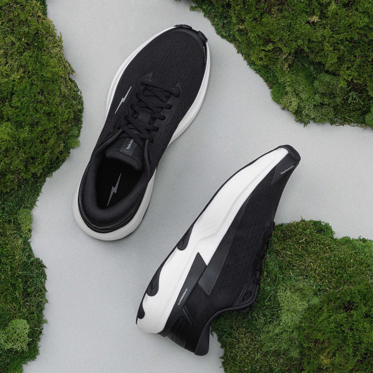 Hylo AXIS Running Shoes Black Undyed showing top view of engineered Jacquard warp knit upper and inner side view displaying bio-based cushioning with lightweight stability