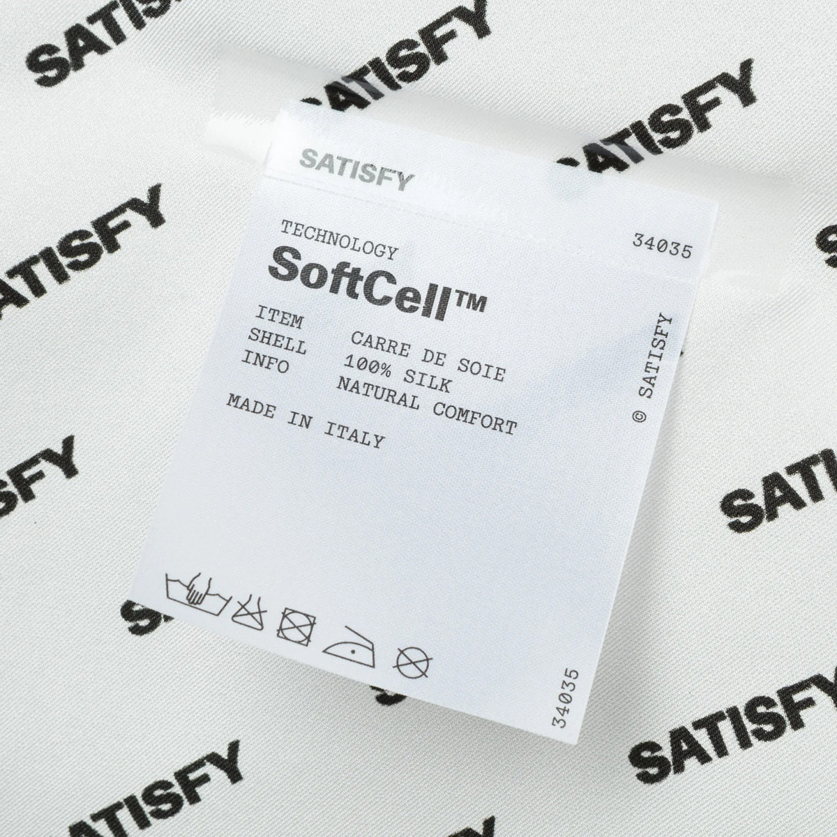Satisfy Carré de Soie SoftCell™ Bandana in White Down — closeup showing fully detachable exterior care label on white down SoftCell™ Italian silk construction