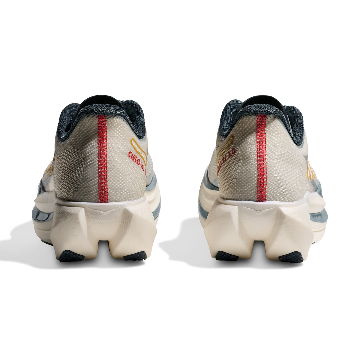 Rear view of two Hoka Cielo X1 3.0 Running Shoes in Alabaster/Yellow Gold, featuring chunky white soles, blue accents, a red vertical stripe, and “CIELO X1” text in red on the back. This carbon racing shoe showcases a responsive PEBA midsole, all set against a white background.