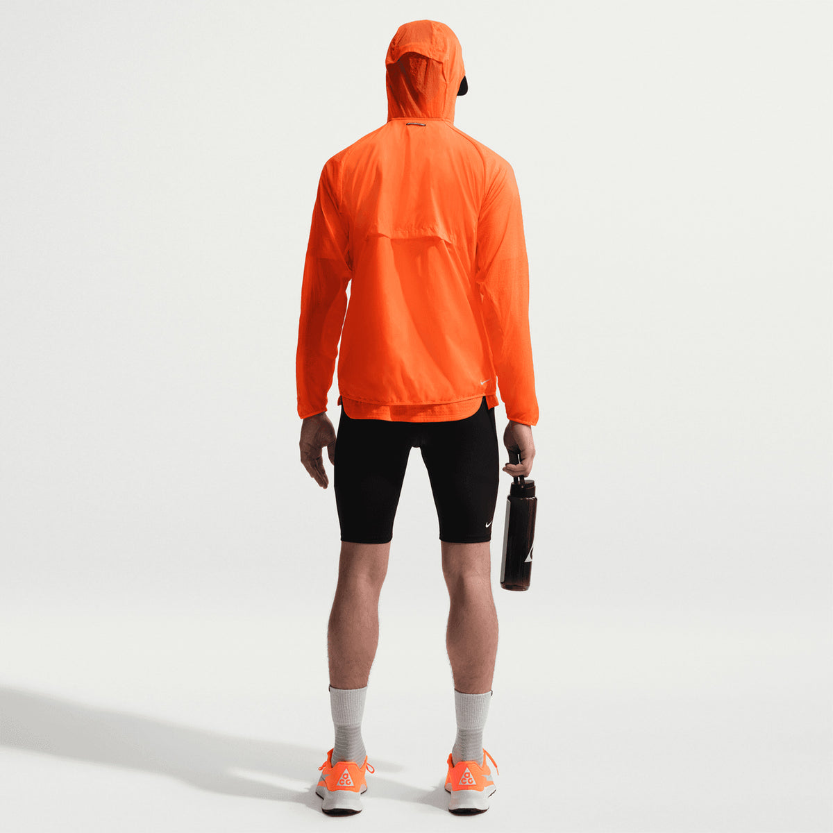 Men's Nike ACG Dri-FIT ADV Half Tights Black Summit White full body back view on male runner showing comprehensive pocket system and elastic waistband with drawcord