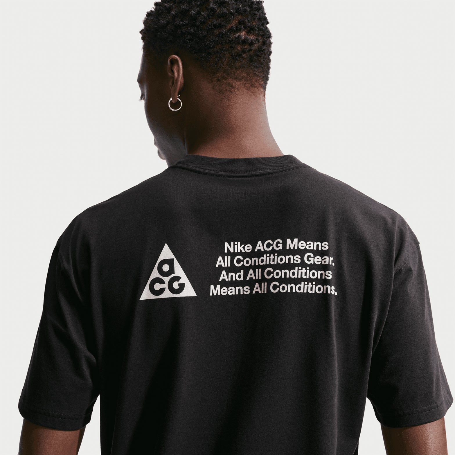 Men's Nike ACG Dri-FIT T-Shirt Black close-up back showing bold ACG text print details and Dri-FIT technology construction