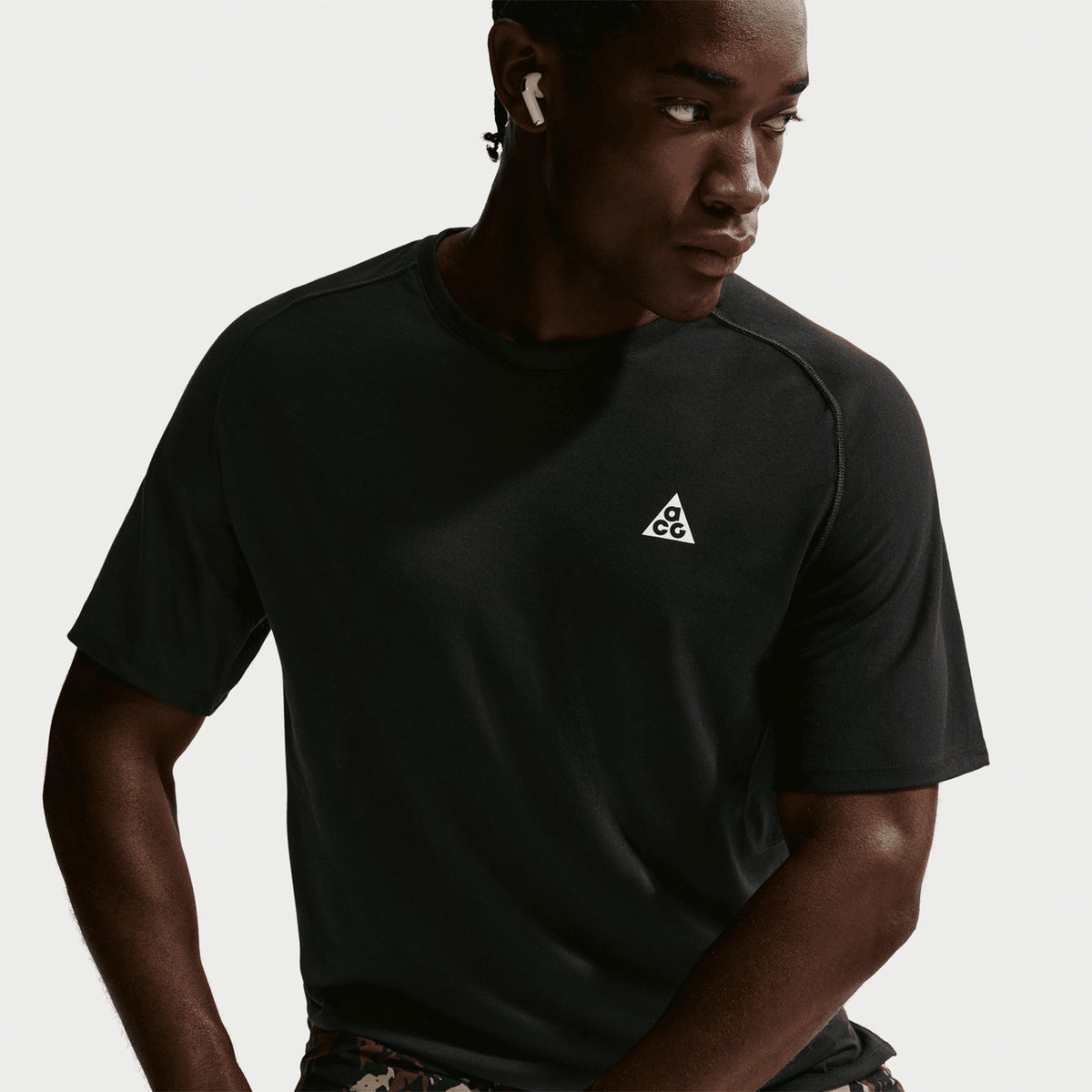 Men's Nike ACG Solar Chase Dri-FIT ADV Trail Running Tee Black Summit White close-up of cotton-poly fabric showing slightly brushed handfeel with Dri-FIT ADV moisture-wicking and targeted mesh ventilation for trail running comfort