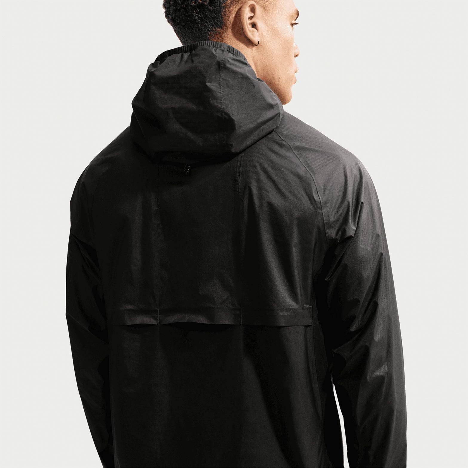 Nike ACG Trailwind men's Storm-FIT ADV jacket in Anthracite / Summit White — back product shot showing anthracite windproof waterproof construction, back vents for breathability and reflective ACG and Swoosh logos