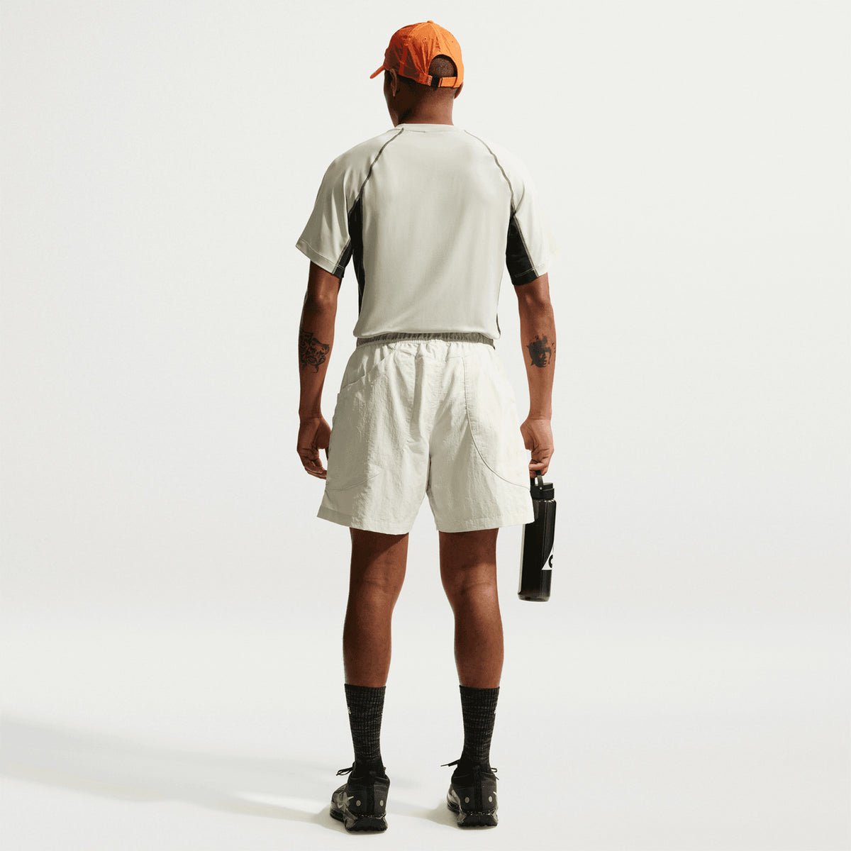 Men's Nike ACG Wildsee Dri-FIT Base-Layer Tee Sea Glass Black Spruce Summit White full body back view on male model showing UV-resistant construction with Dri-FIT moisture-wicking and ACG nesting system design for mountain running and layering