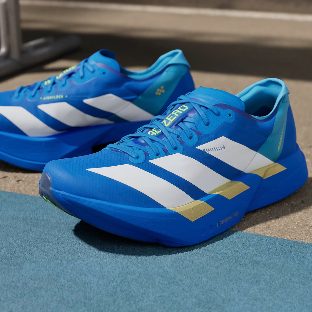 Men's adidas Adizero Adios Pro 4 Running Shoes Blue Cloud White Lime Burst close-up angled front showing lightweight racing construction with carbon fibre ENERGYRODS 2.0 and LIGHTSTRIKE PRO foam for elite competition from 5K to marathon