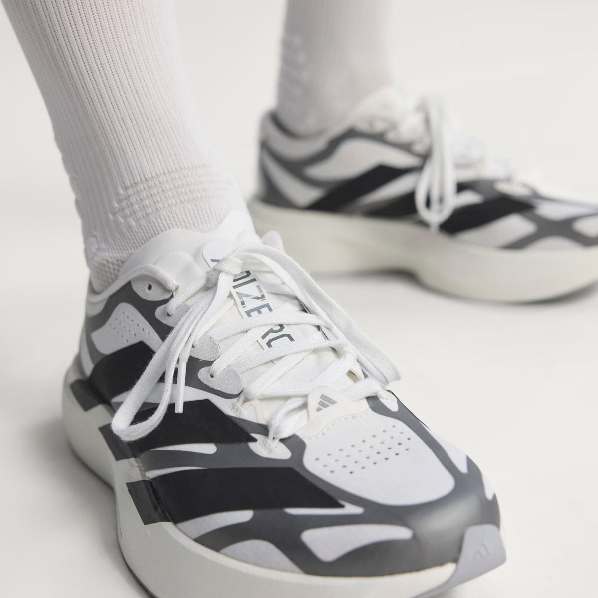 adidas Adizero EVO SL EXO men's running shoe in Cloud White / Core Black / Iron Metallic — top-down view showing cloud white woven shell upper, exoskeleton overlay system, lace closure and core black accent detailing