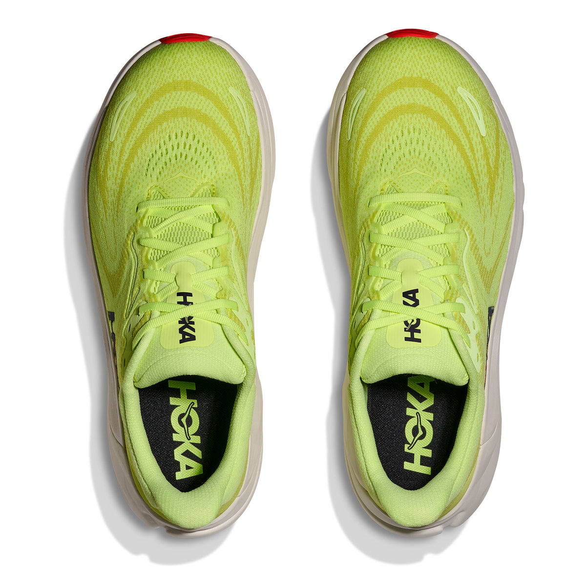Top view of a pair of Hoka Men’s Arahi 8 Running Shoes in Neon Yuzu / Neon Flame, featuring vibrant yellow uppers with white soles and red accents at the toe. Renowned for their stability, these top-rated running shoes display the Hoka logo on both the tongues and insoles. The shoes are positioned side by side, facing upward.
