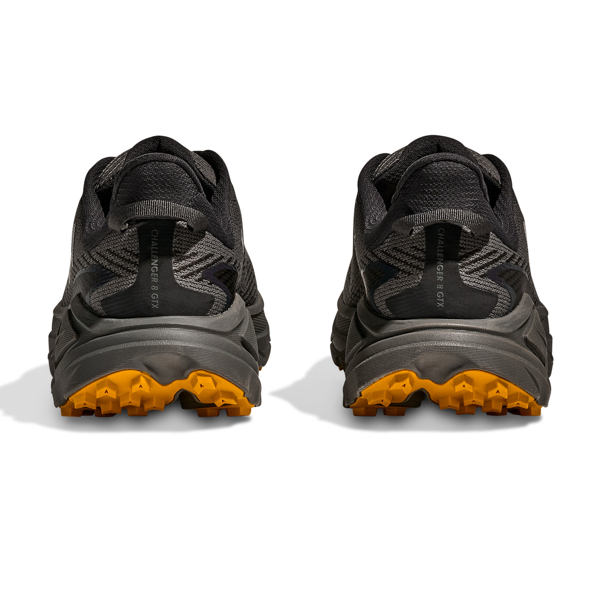 A pair of Hoka Men’s Challenger 8 GORE-TEX Trail Running Shoes in Asphalt Grey and Varsity Yellow, shown from the back, featuring rugged yellow outsoles for traction and the Challenger 8 GTX label on the heel.