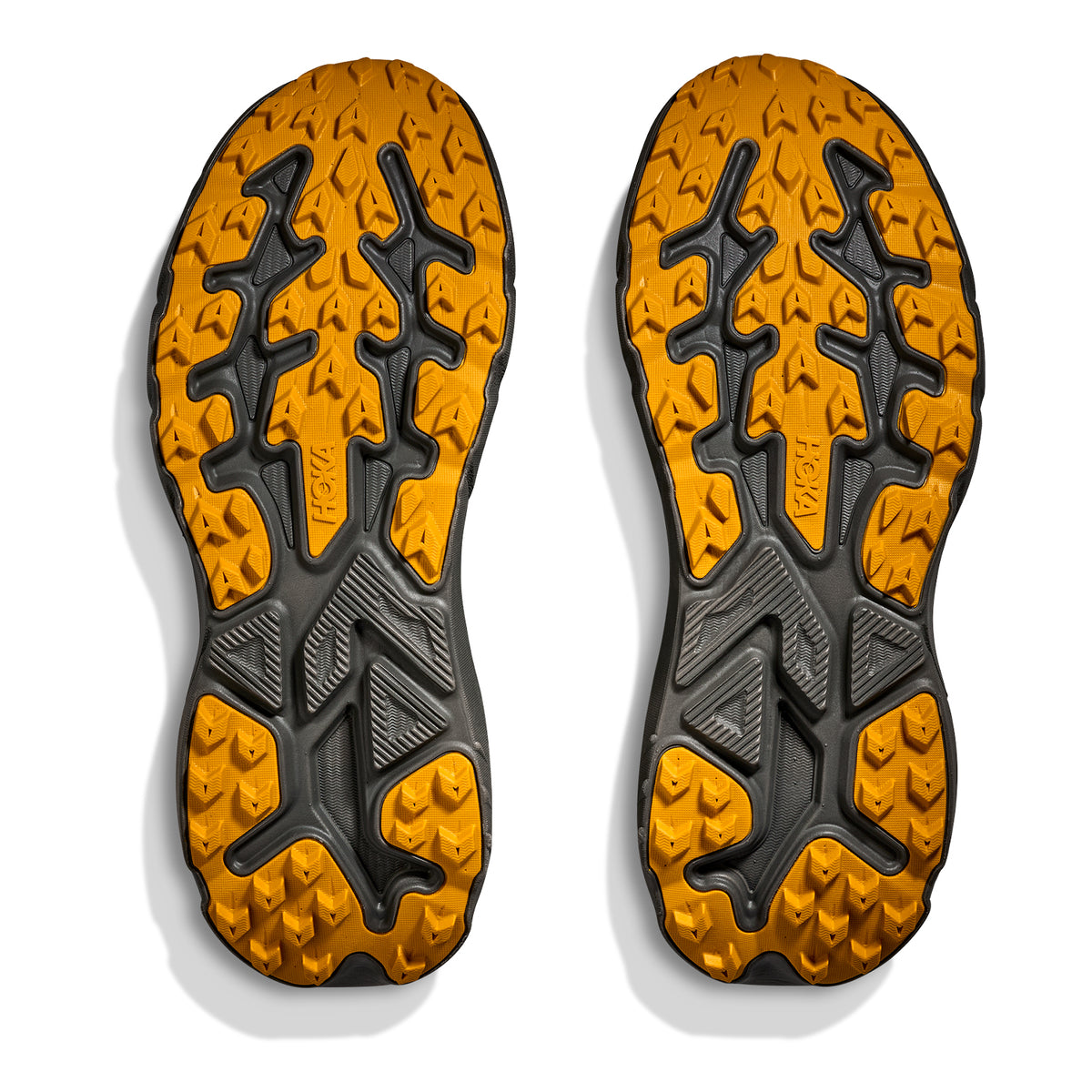 A pair of Hoka Men’s Challenger 8 GORE-TEX Trail Running Shoes in Asphalt Grey and Varsity Yellow, featuring rugged, textured soles designed for optimal grip and traction, photographed on a white background.