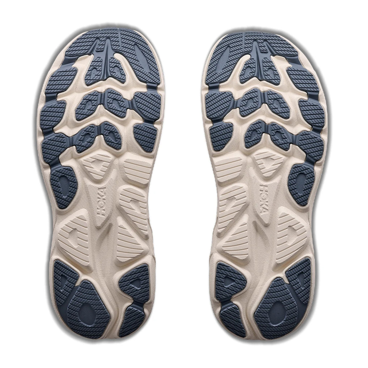 Outsoles of two Men’s Clifton 11 Running Shoes Faded Navy with a lugged tread pattern and beige compression moulded EVA foam midsoles.