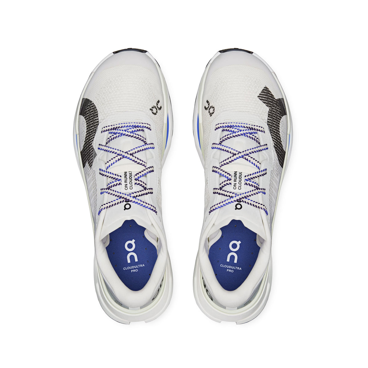 A pair of Men’s Cloudultra Pro Trail Running Shoes in Ivory/Iceberg by On, featuring black and blue details, blue insoles, and blue-and-white laces, are shown from above. The On brand logo and the product name appear on the tongues, emphasizing their design for mountain terrain adventures.