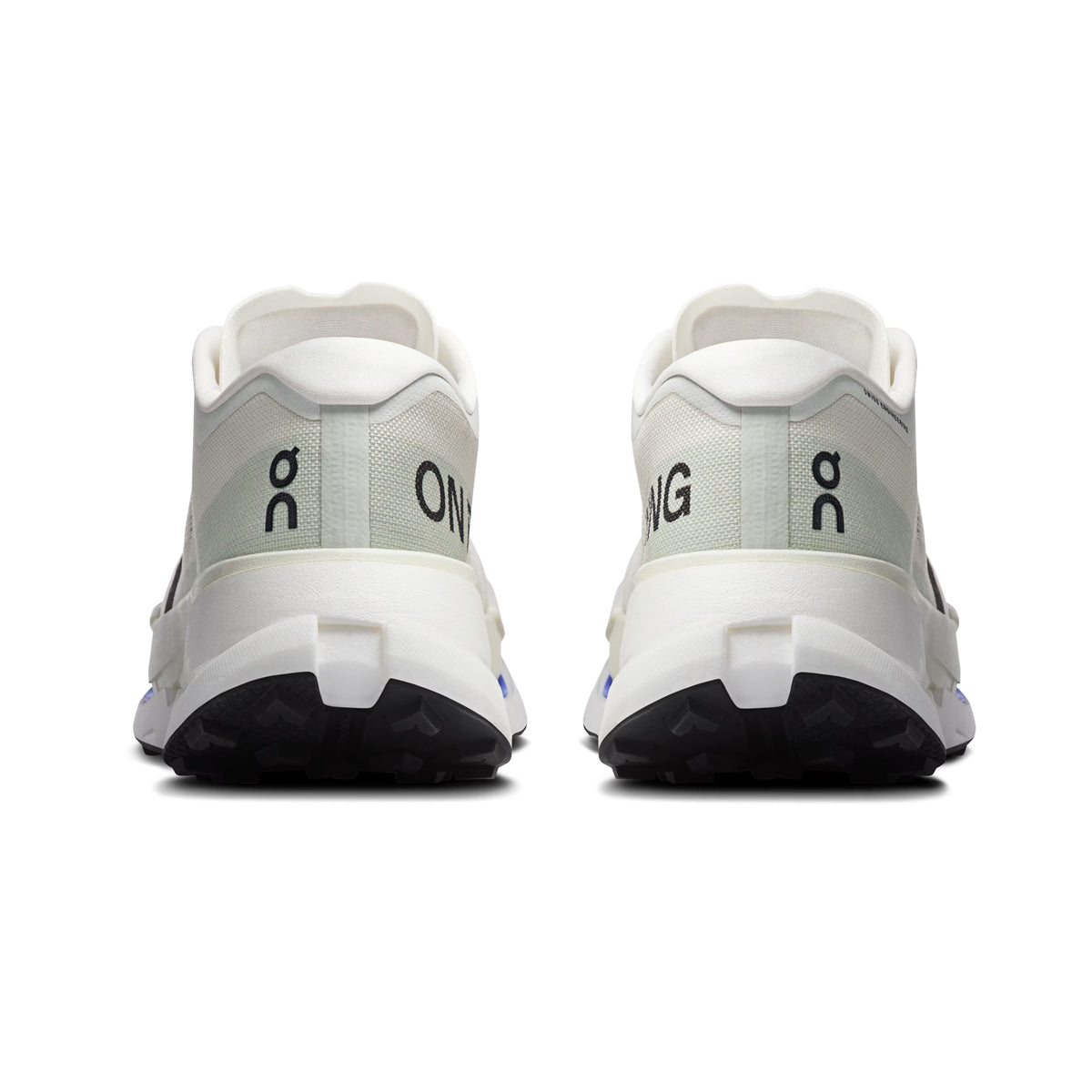 The back view of the Men’s Cloudultra Pro Trail Running Shoes in Ivory / Iceberg by On, featuring black soles and designed for mountain trail running; “ON” appears on the left shoe and a “G” with a logo above it is displayed on the right shoe.