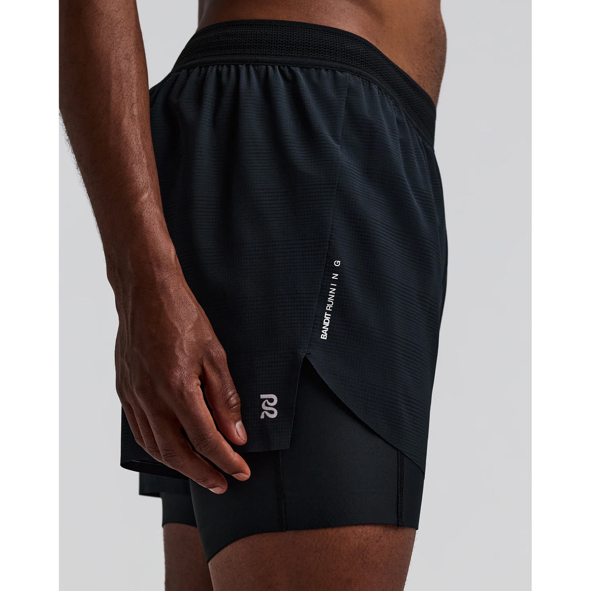 Men's Bandit CoolGrid 2-in-1 Run Short Black side view on male runner showing CoolGrid breathable outer with GripDot hems and waterproof leg pocket for comfortable running and racing