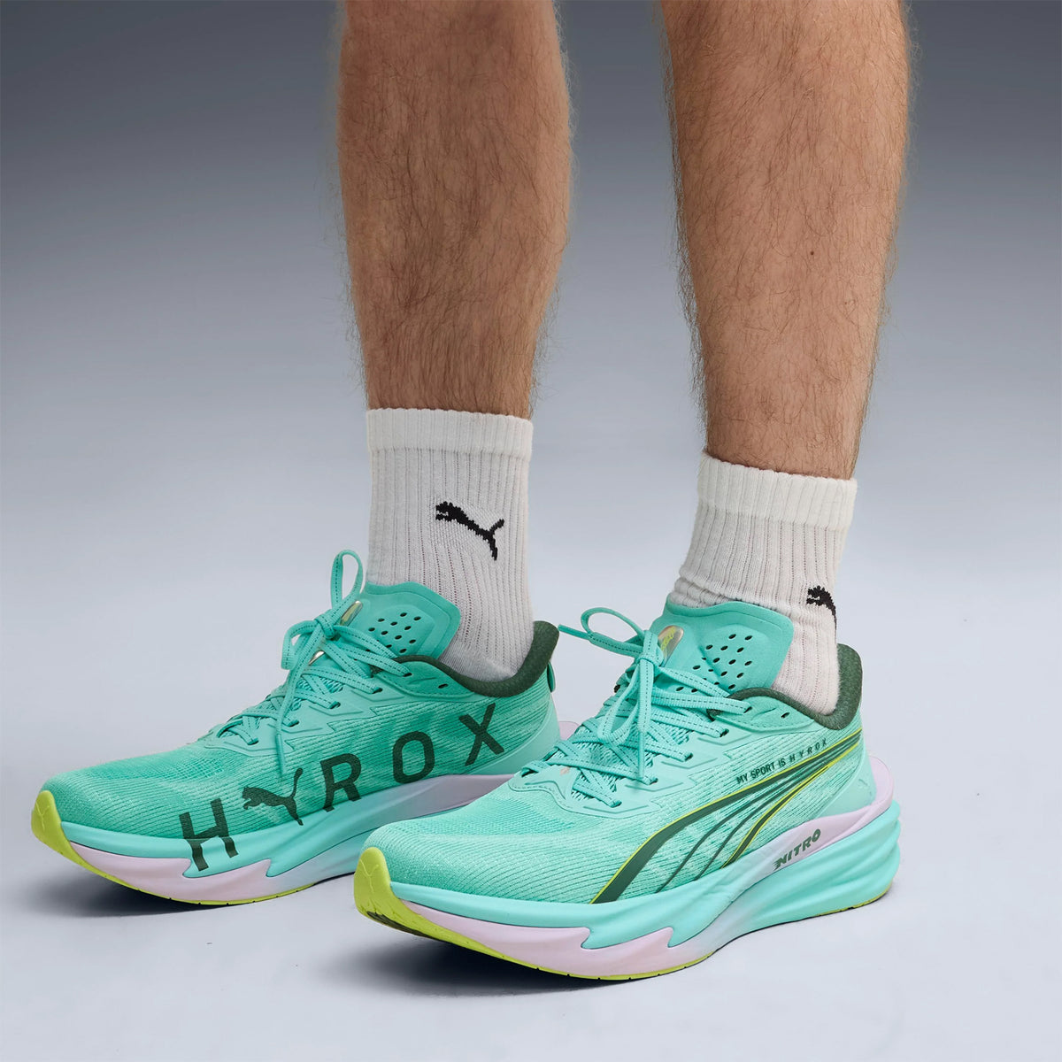 Men's Puma Deviate NITRO 4 HYROX Running Shoes Intense Mint Light Lavender side view on male athlete showing NITROFOAM cushioning with carbon PWRPLATE for propulsive speed during HYROX running intervals and fitness stations