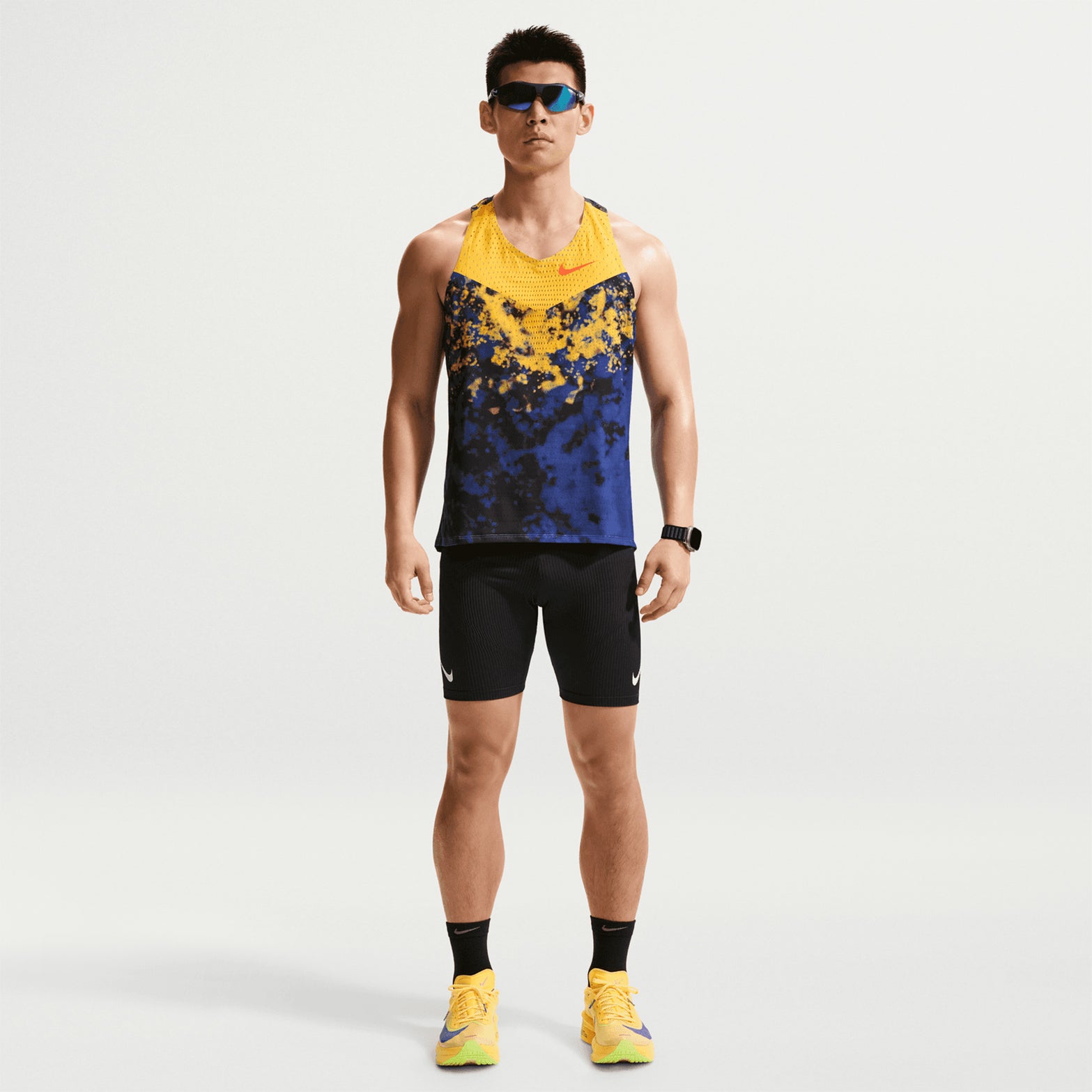 Men's Nike Dri-FIT AeroSwift ADV Running Vest Citron Pulse Lapis Bright Crimson front full body view on male runner showing racing vest with Dri-FIT ADV technology for race day and tempo training