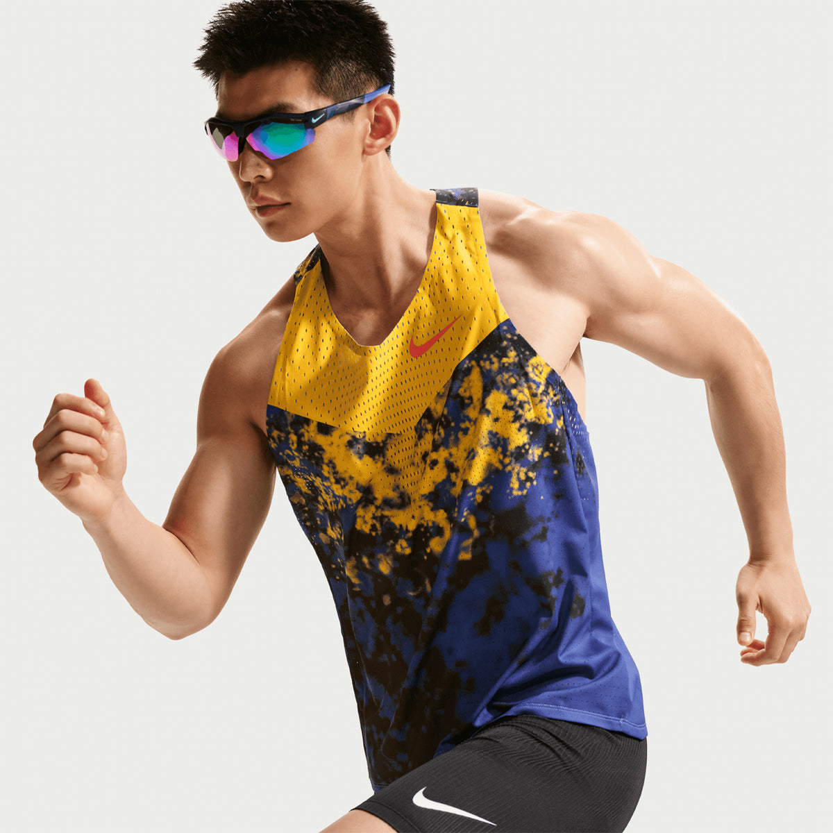 Men's Nike Dri-FIT AeroSwift ADV Running Vest Citron Pulse Lapis Bright Crimson side view on male runner showing racing vest with Dri-FIT ADV moisture-wicking and breathable construction for race day and tempo efforts