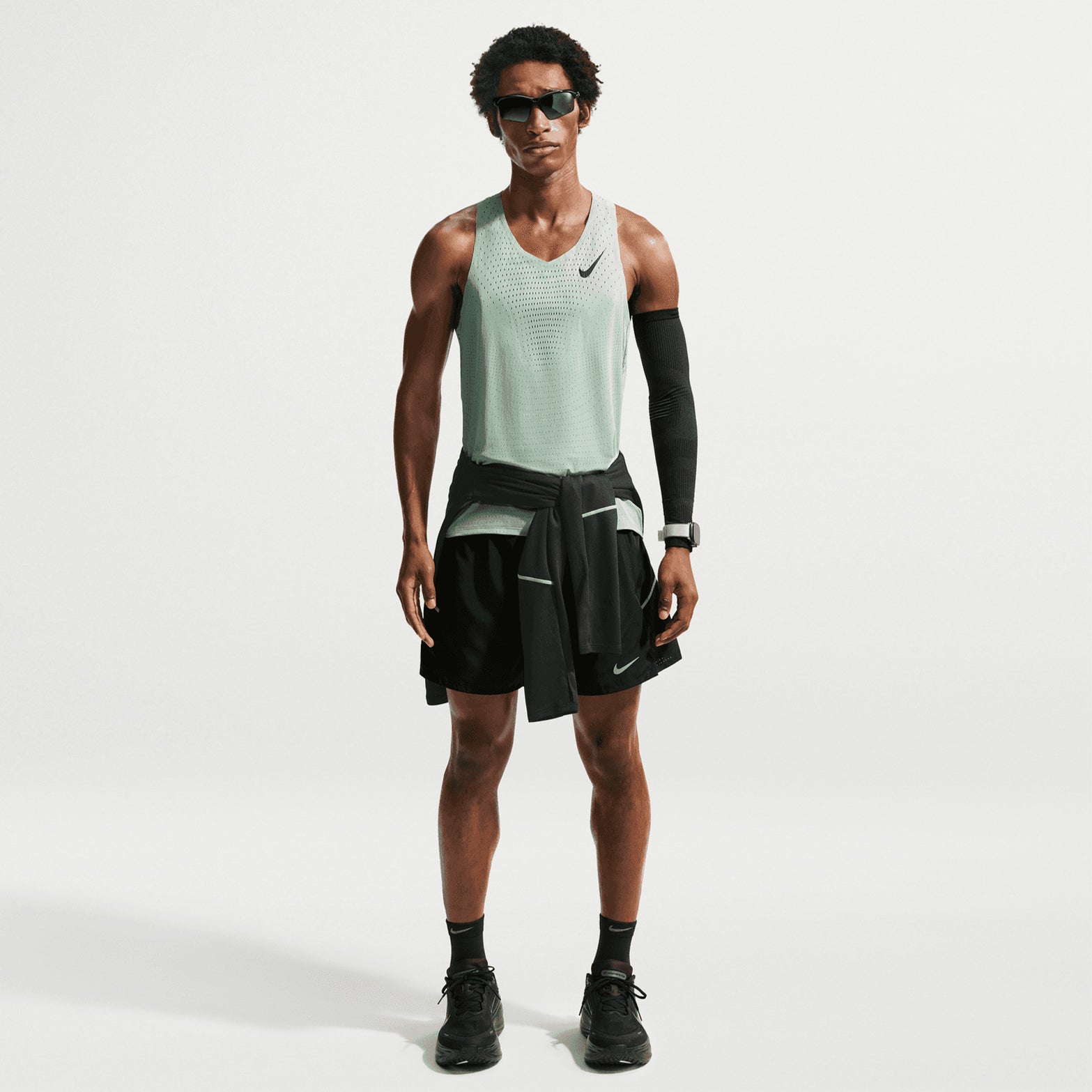 Men's Nike Dri-FIT AeroSwift ADV Running Vest Green full body front view on male runner showing lightweight racing fit and strategic ventilation placement