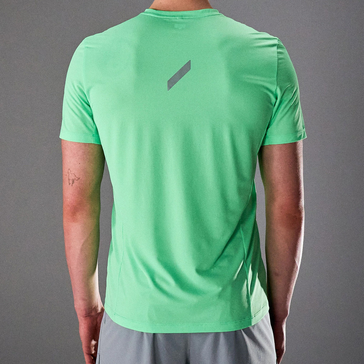 Men's Soar Eco Tech Tee close-up back view on model showing recycled Italian mesh fabric texture and reflective Soar logo detail