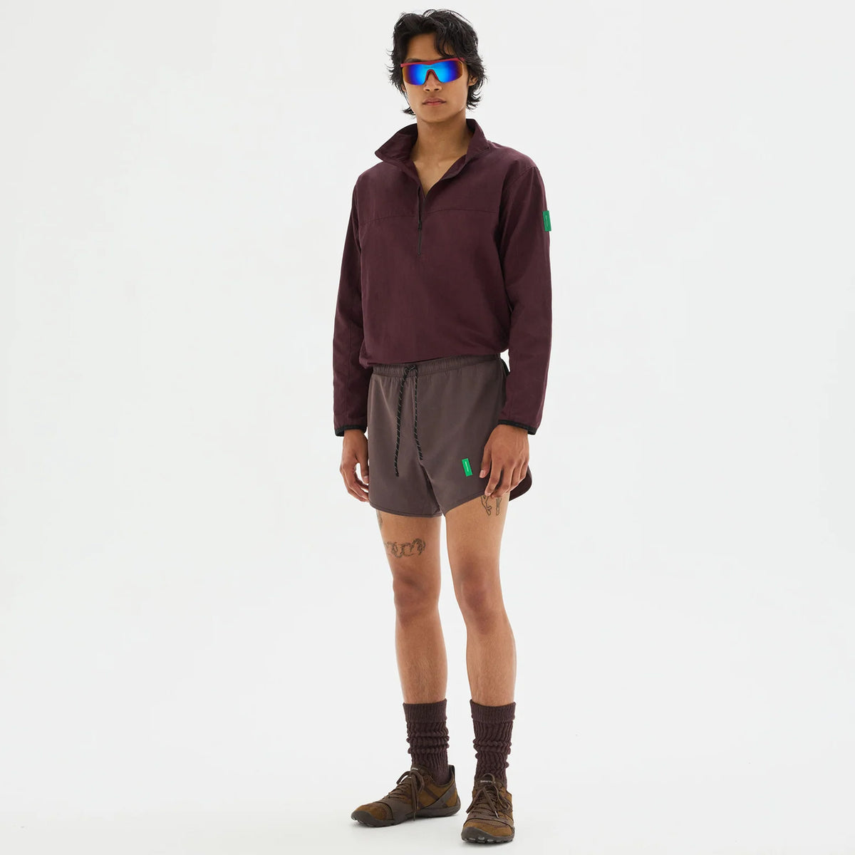 District Vision Men's Half Zip Nylon Windbreaker Blackberry full body view on male runner showing half-zip front with integrated eyewear storage and highly water-resistant Japanese shell fabric