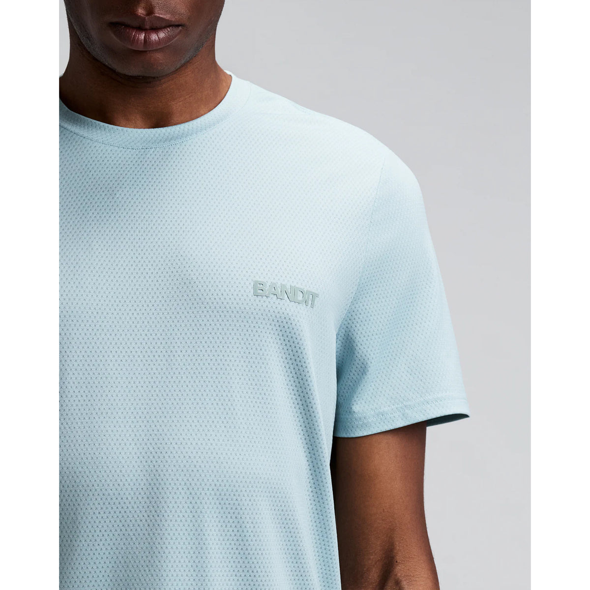 Men's Bandit Micromesh Run Tee Lagoon close-up of front showing subtle two-tone Bandit logo branding with ultra-breathable Micromesh fabric and Oeko-Tex certified BPA-free construction