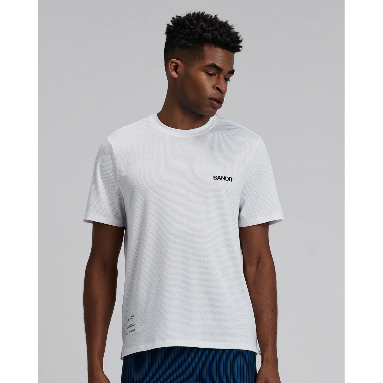Bandit Micromesh Run Tee men's in White — front view worn on model showing relaxed fit, Micromesh™ fabric drape and dyed-to-match reflective graphic at centre front