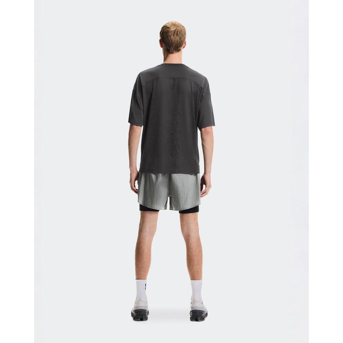 Men's On Performance Volt-T Iron full body back view on male runner showing versatile relaxed cut with quick-dry moisture-wicking performance for everyday activities