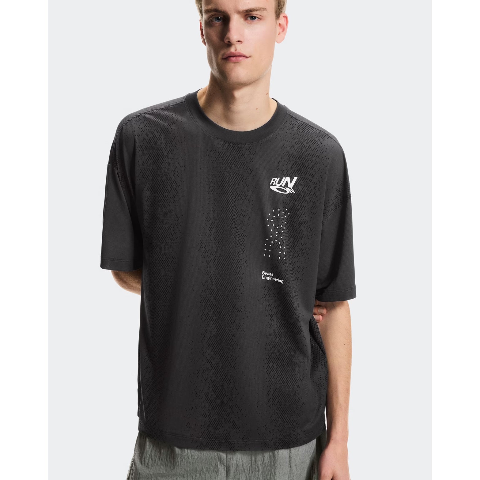 Men's On Performance Volt-T Iron front view on male runner showing lightweight moisture-wicking construction with bold typographic run-culture design