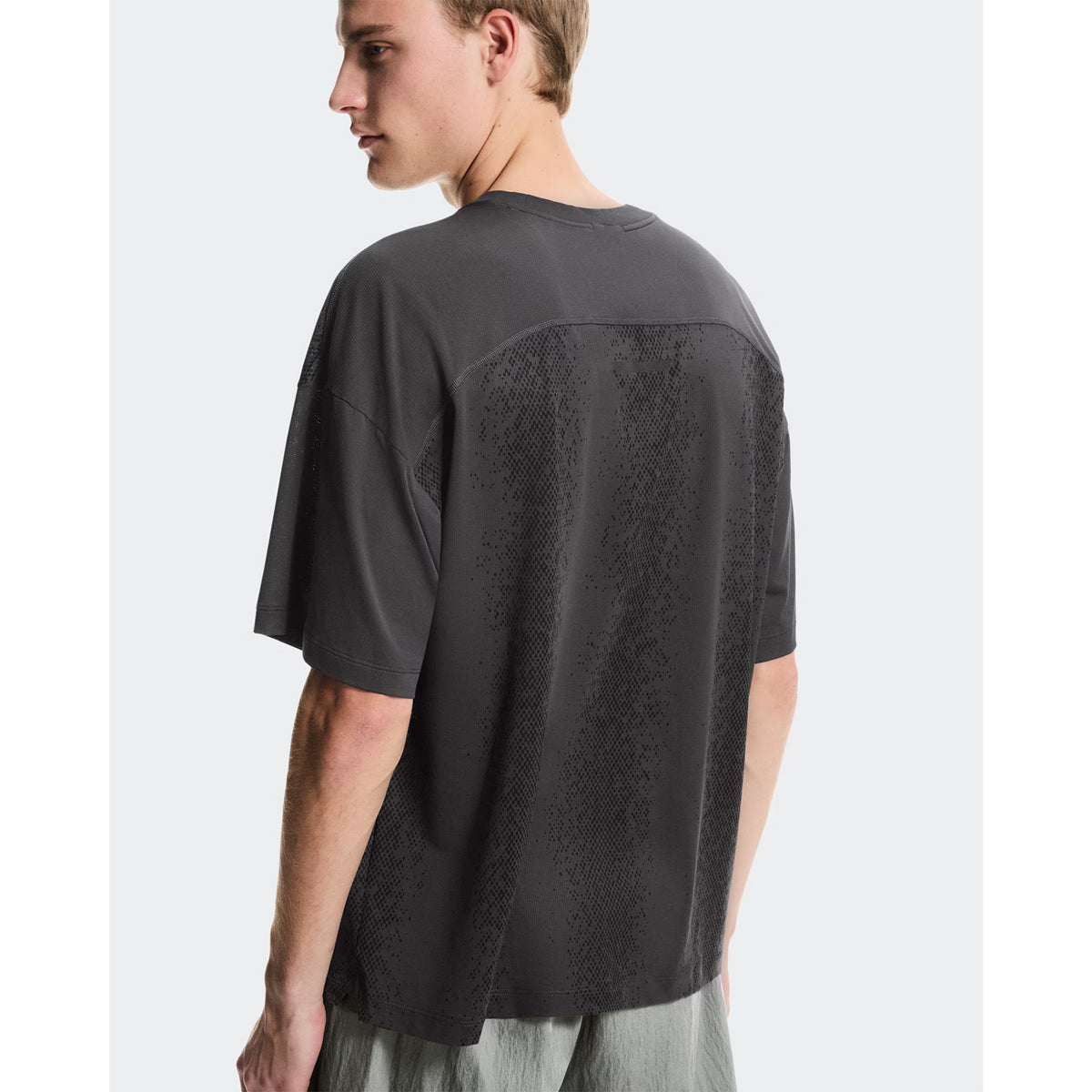 Men's On Performance Volt-T Iron back view on male runner showing relaxed fit with On DryTec technology for versatile training and recovery wear