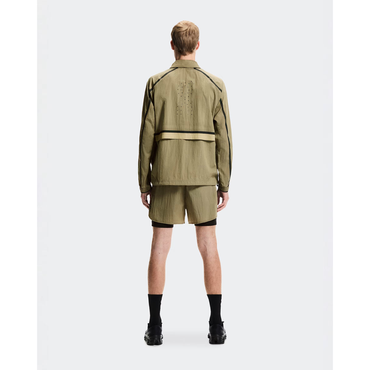 Men's On Performance Volt Shorts Safari full body front view on male runner showing dual-layer design with windproof outer and moisture-wicking inner for everyday training