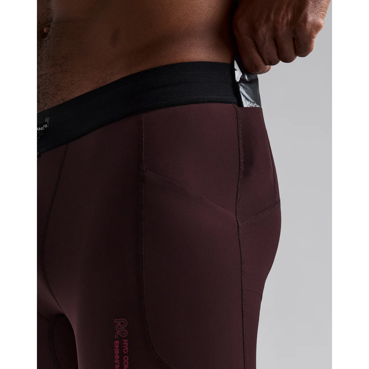 Men's Bandit SoLite Quarter Tights Espresso close-up of pocket system showing waterproof drop-in leg pocket with gel pockets and zero-bulk design for running essentials