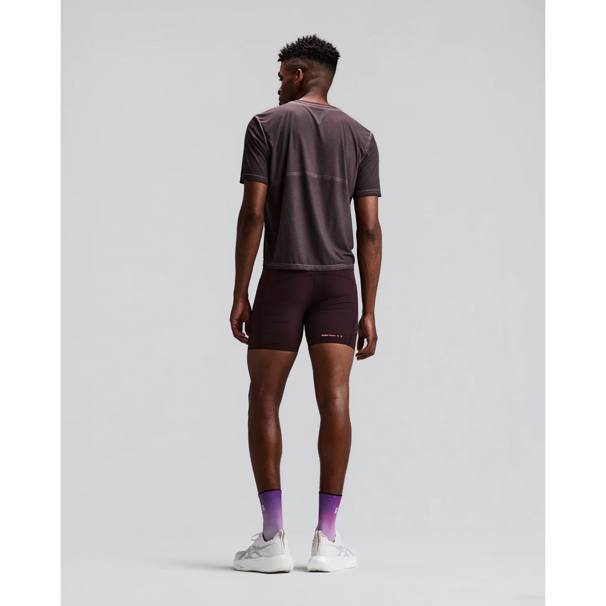 Men's Bandit SoLite Quarter Tights Espresso back full body view on male runner showing waterproof centre back zip pocket with GripDot hem technology and SoLite featherweight compression construction