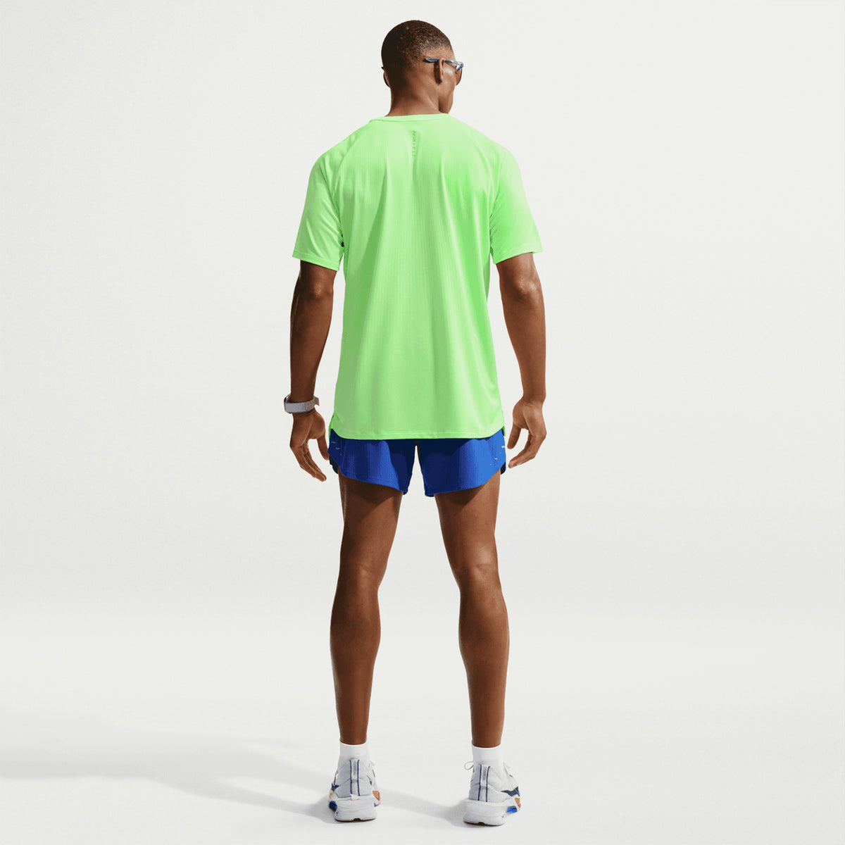 Men's Nike Stride Aero-FIT Running Tee Volt Light Silver full body back view on male runner showing strategic back mesh zones with Aero-FIT technology for maximum breathability and active cooling during warm weather training