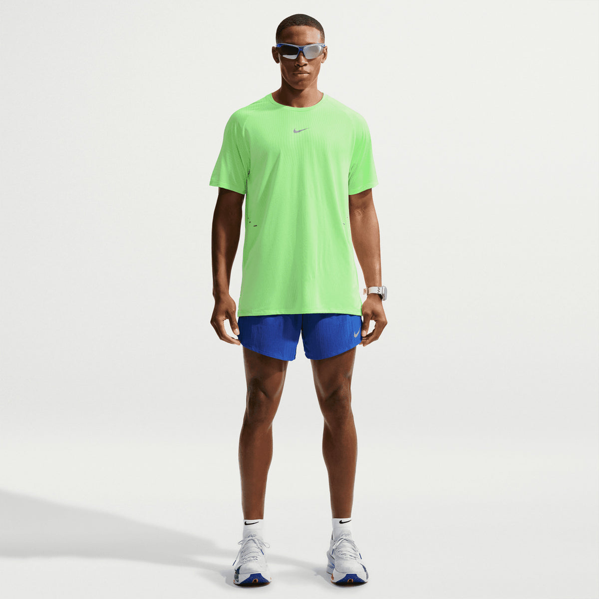 Men's Nike Stride Aero-FIT Running Tee Volt Light Silver full body view on male runner showing lightweight knit with strategic mesh zones and side hem vents for maximum breathability and unrestricted movement