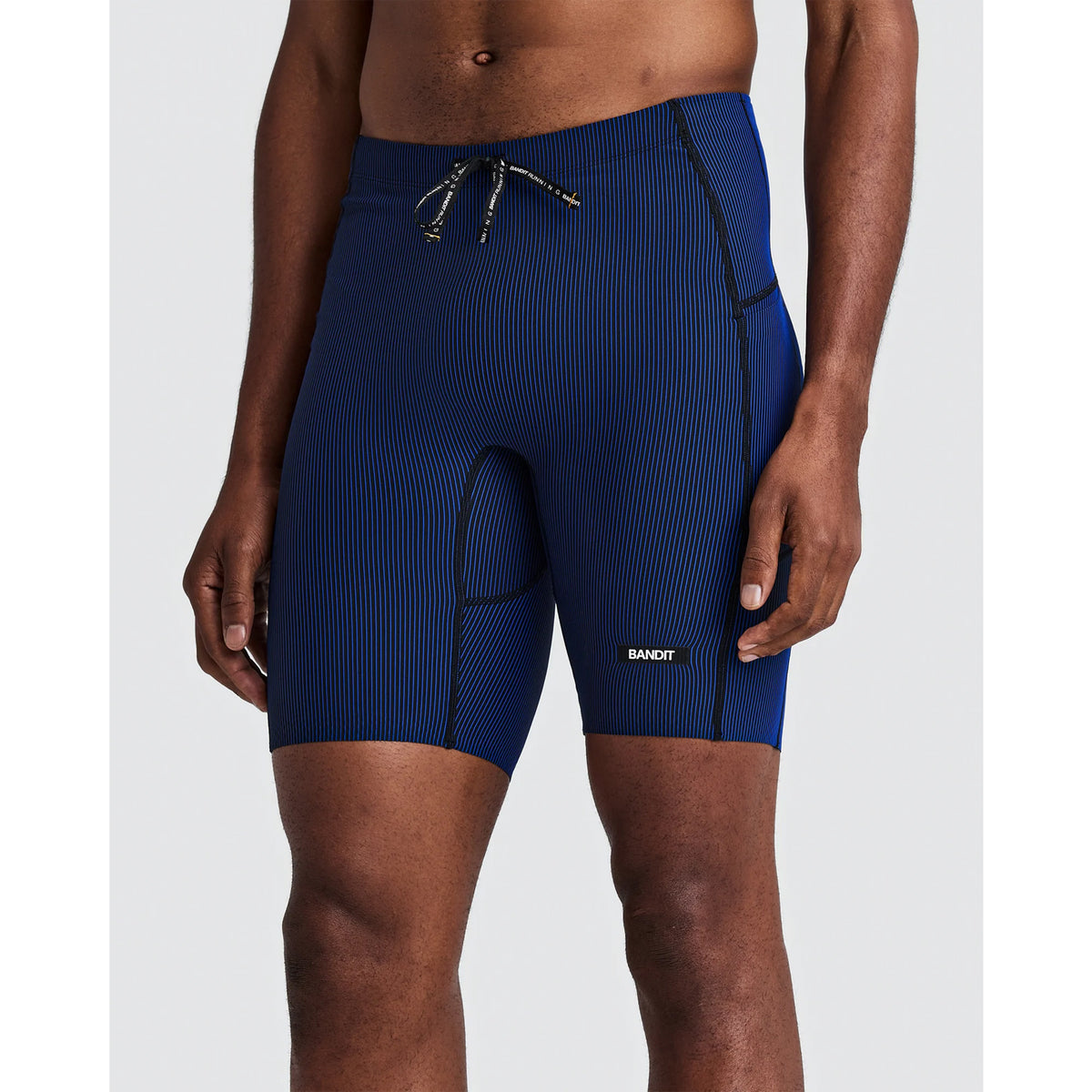 Bandit Men’s Striped Cadence Half Tights Black / Bauhaus Blue featuring a blue and black striped ribbed compression design with a drawstring waist and a small rectangular logo patch on the leg.