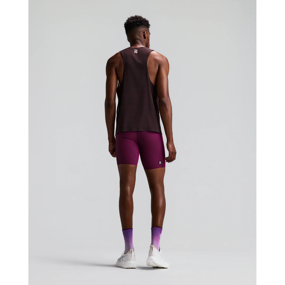 Men's Bandit Striped Cadence Quarter Tights Espresso Azalea back full body view on male runner showing waterproof phone pockets with tee loop, gel pockets and GripDot laser-cut hems for long-distance running