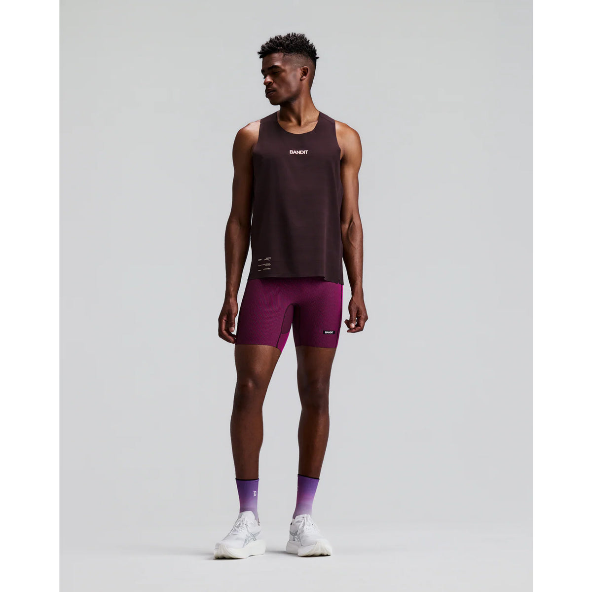 Men's Bandit Striped Cadence Quarter Tights Espresso Azalea front full body view on male runner showing Striped Cadence ribbed compression with GripDot hems and seven-pocket system for road running and racing