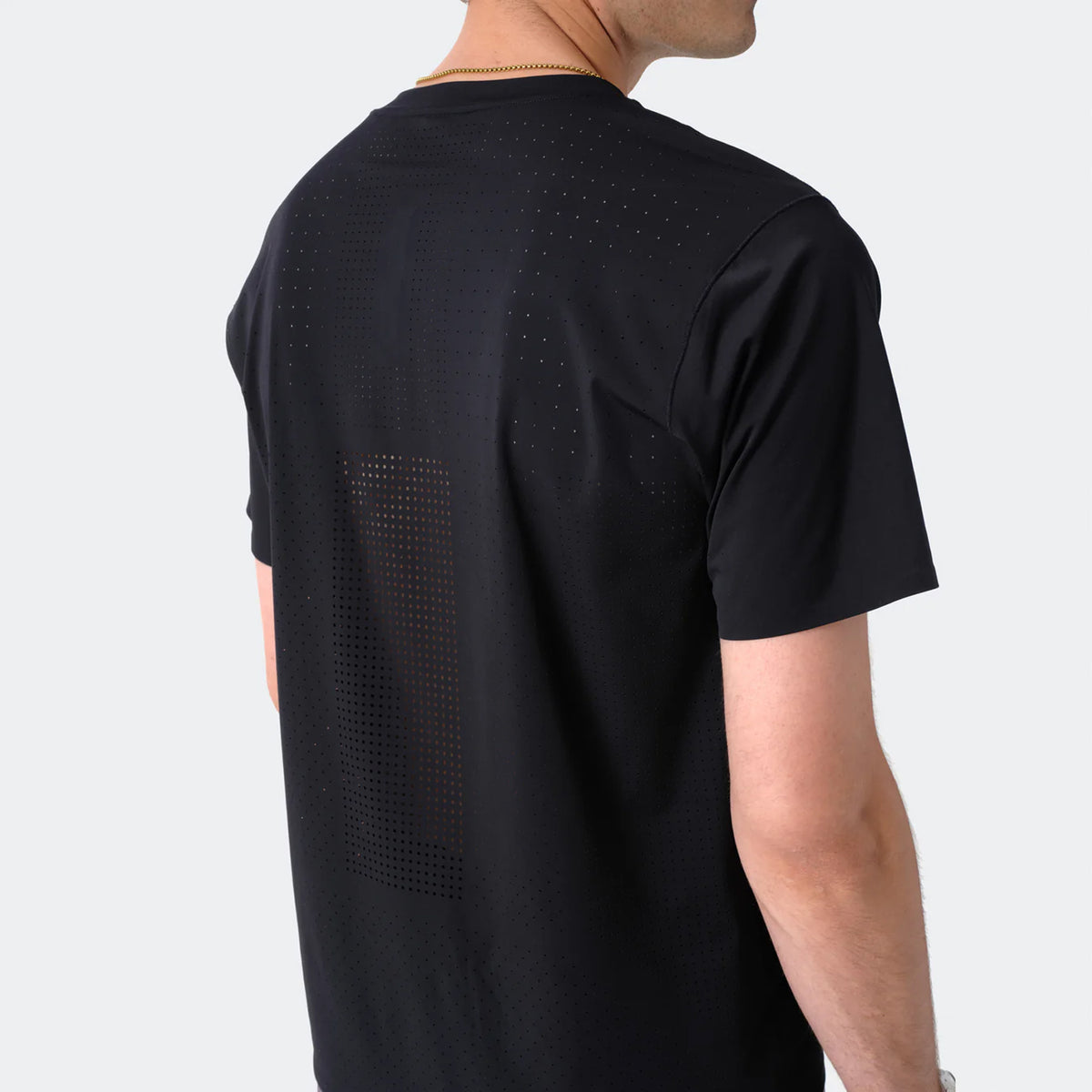 Men's Raide Thermal Dispersion Tee Black back view on male runner showing densely perforated centre back heat zone with body-mapped laser-cut ventilation for evaporative cooling during sustained efforts