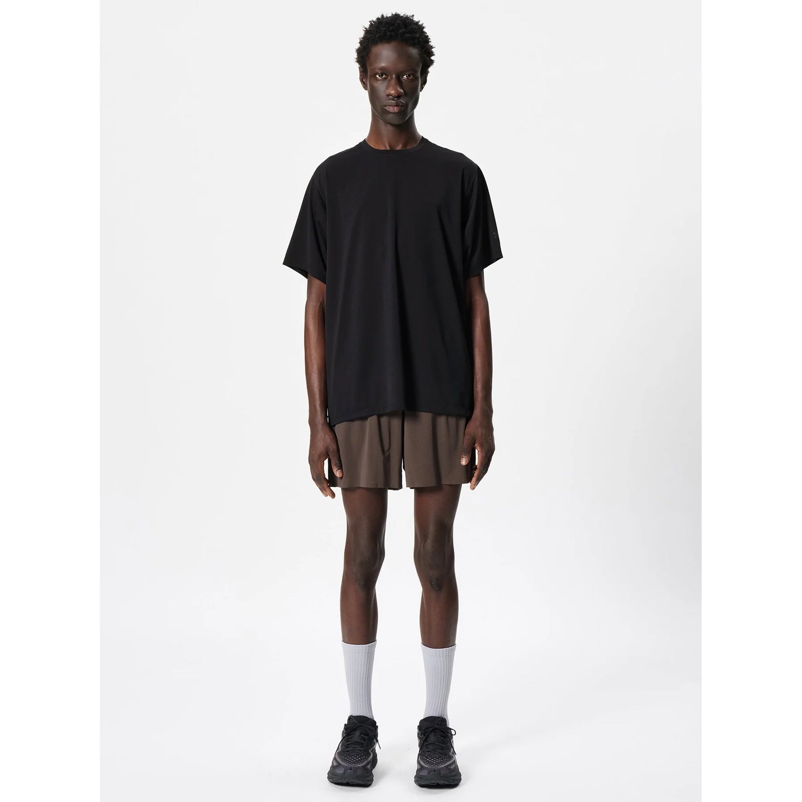 Goldwin Men's WF-Dry Tee Black full body view on male runner showing regular fit with modified raglan sleeves for shoulder range of movement