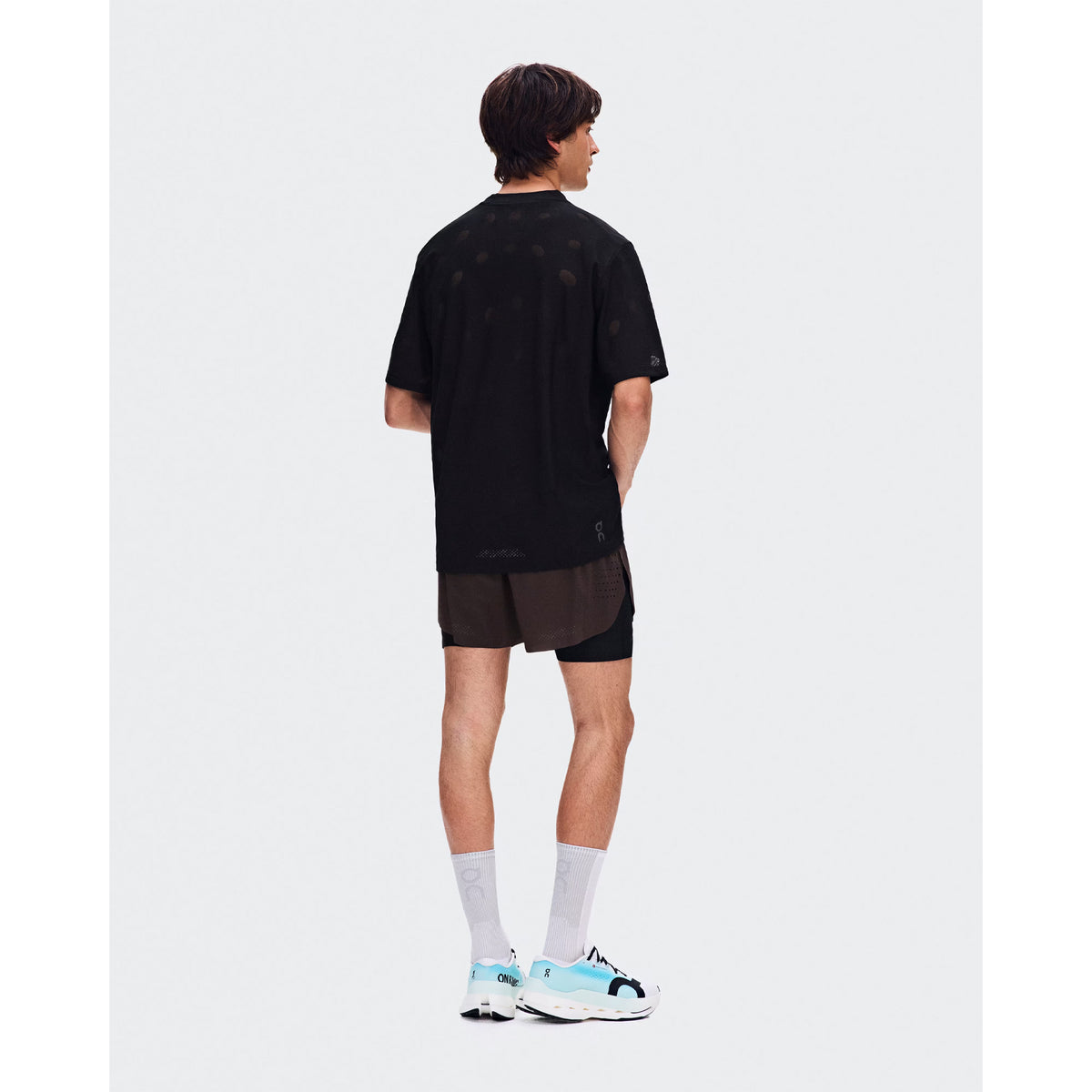 Men's On Zero-T Breathe Black back full body view on male runner showing reflective detailing with minimalist jacquard construction and On DryTec quick-drying fabric for training runs