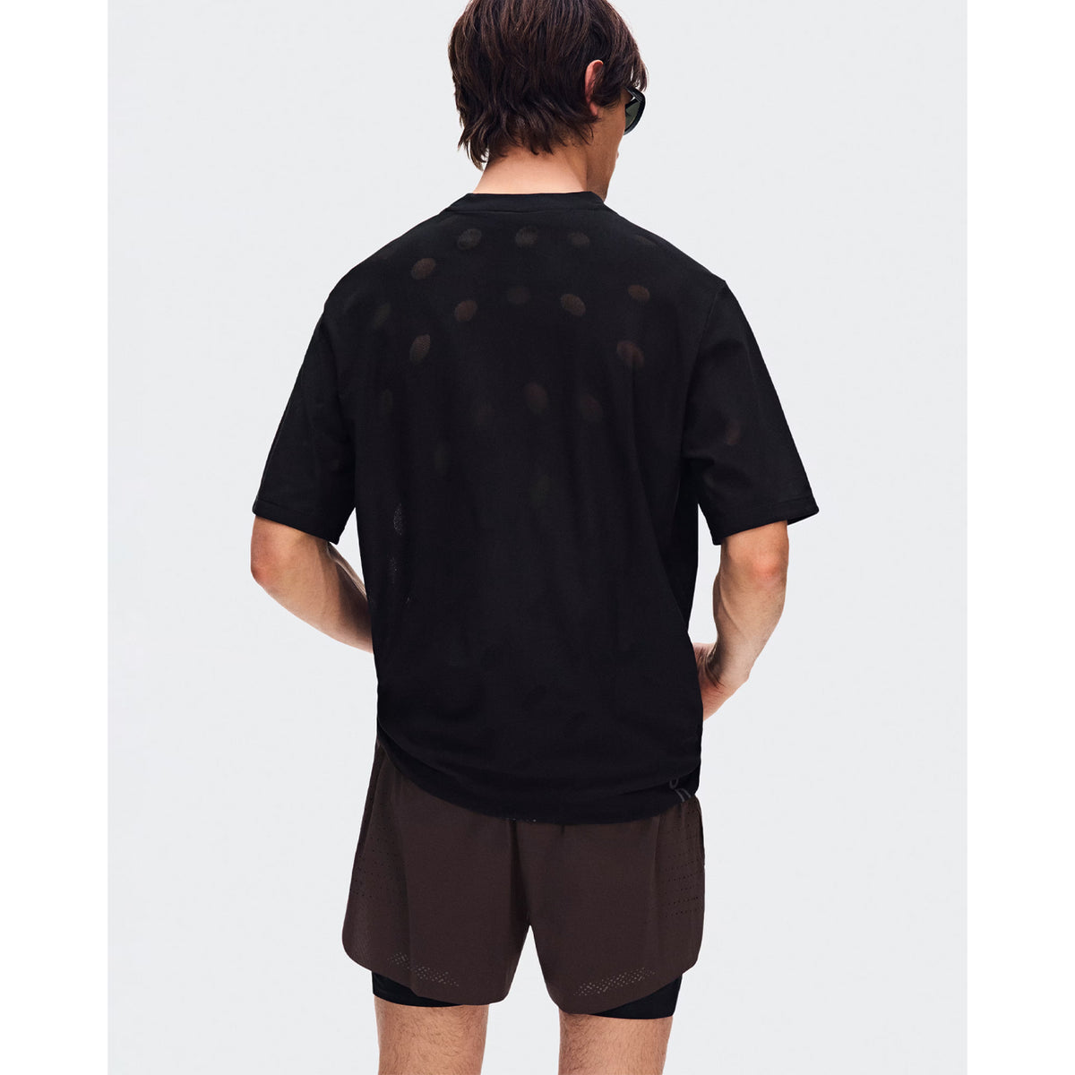 Men's On Zero-T Breathe Black back view on male runner showing reflective detailing with functional jacquard fabric and On DryTec moisture-wicking construction
