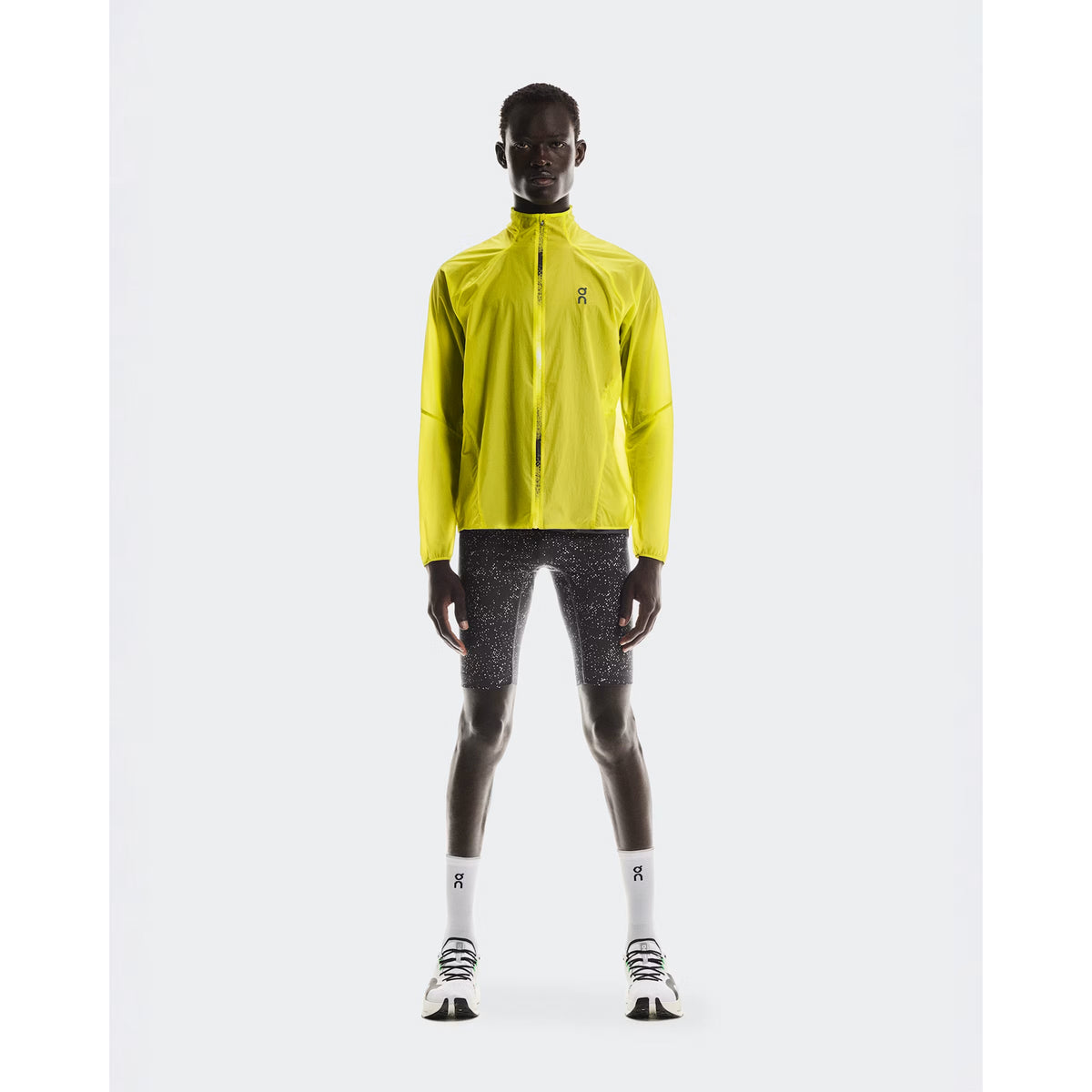 Men's On Zero Jacket Lime full body front view on male runner showing ultralight packable design with windproof water-repellent protection for all-weather running