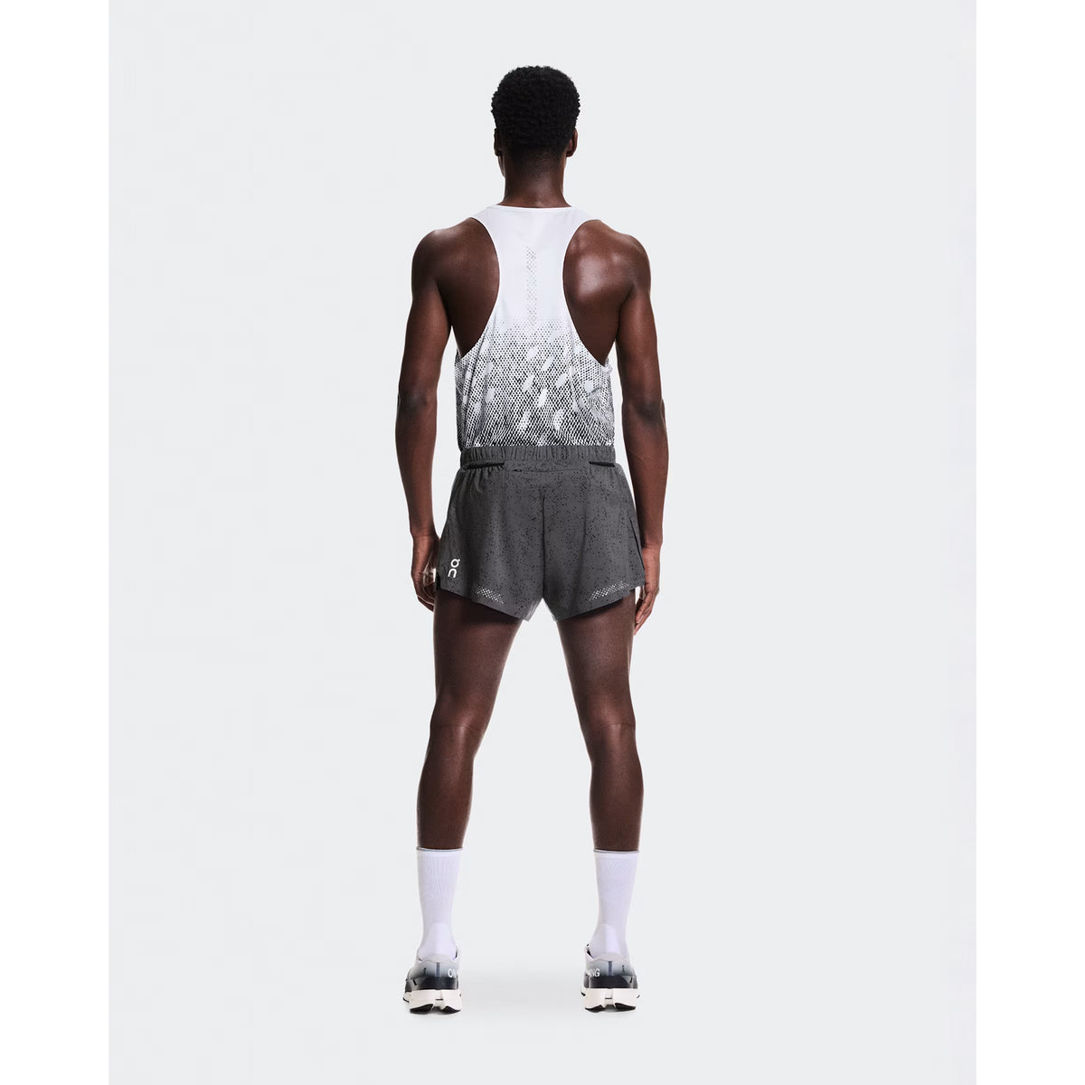 Men's On Zero Shorts Grey Black full body back view on male runner showing zip pocket and two mesh gel pockets for storage