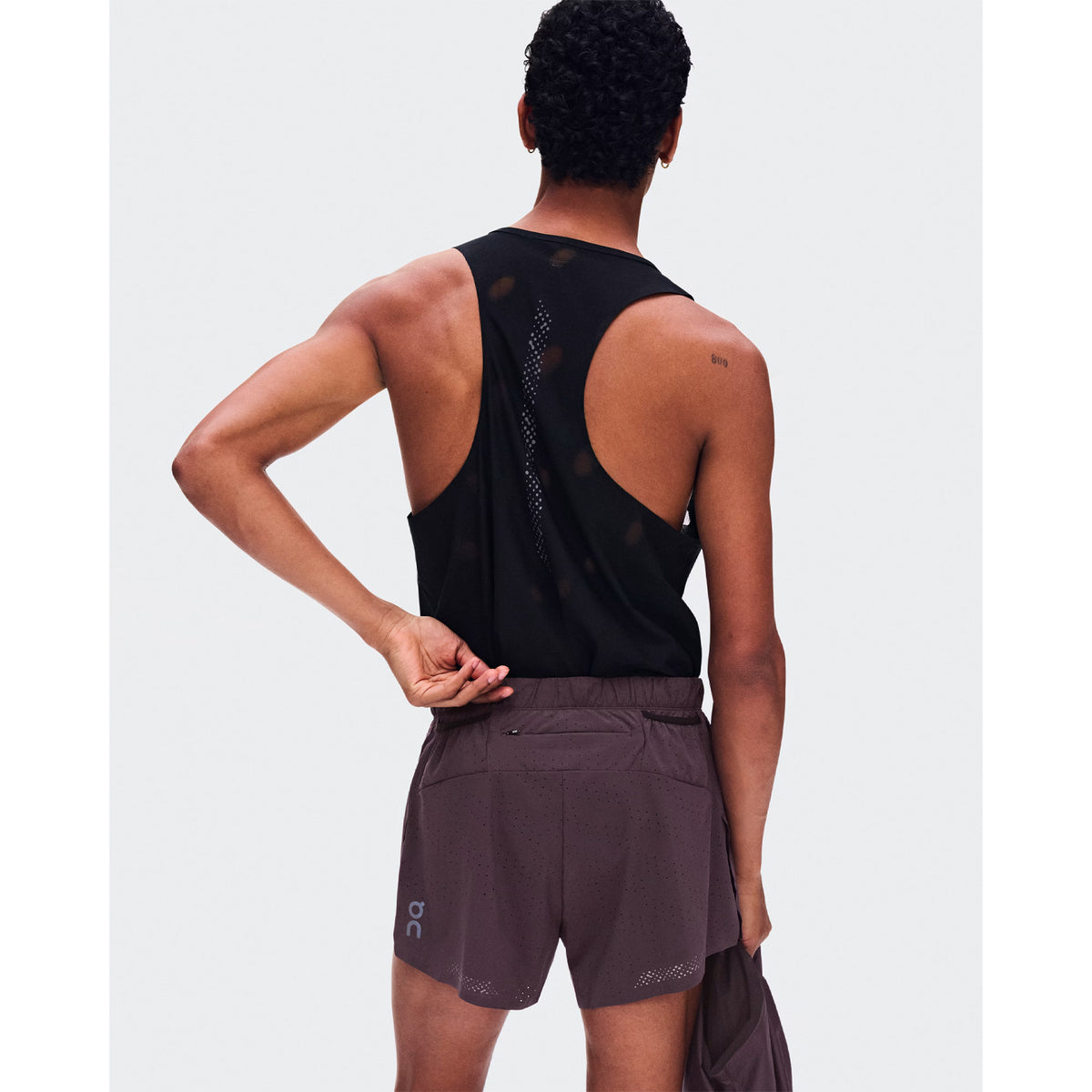 Men's On Zero Shorts Urchin back view on male runner showing zip pocket and two gel mesh pockets with perforated ventilation construction for race day storage and airflow