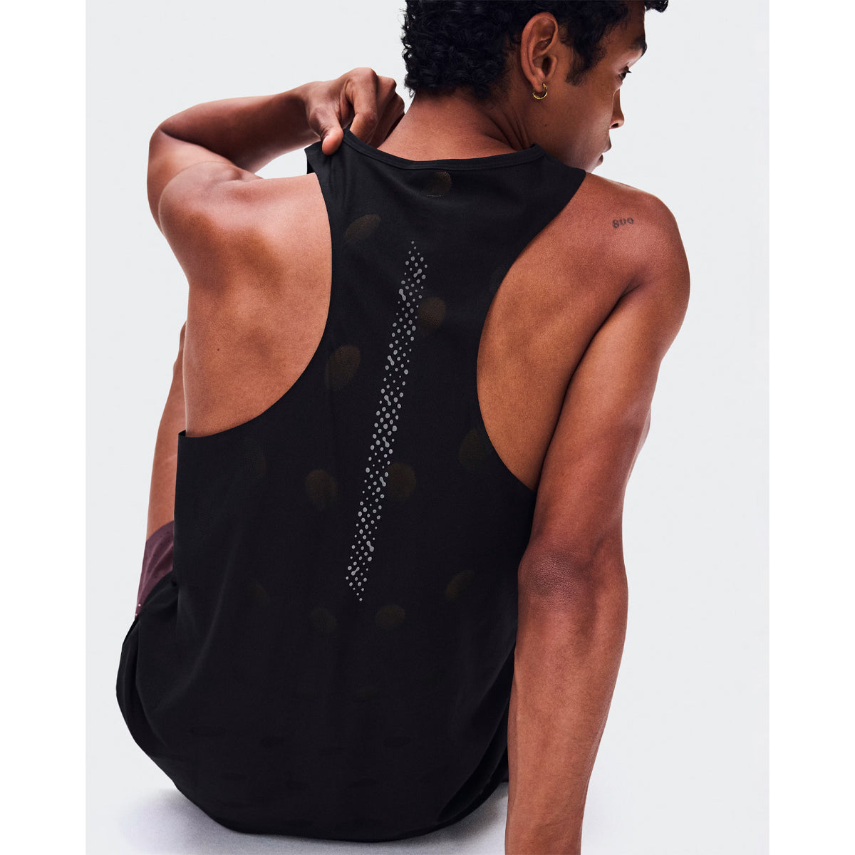 Men's On Zero Tank Breathe Black close-up of back showing functional jacquard construction with signature reflective detailing and minimal seam design for distraction-free race day performance