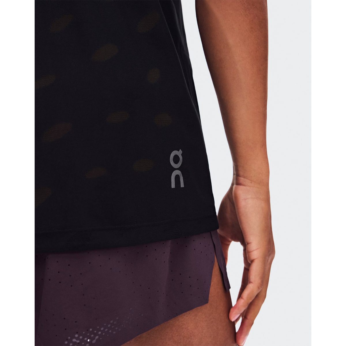 Men's On Zero Tank Breathe Black close-up of hem showing ultralight functional jacquard construction with minimal seam design and On DryTec breathable moisture-wicking fabric for distraction-free training and race day performance