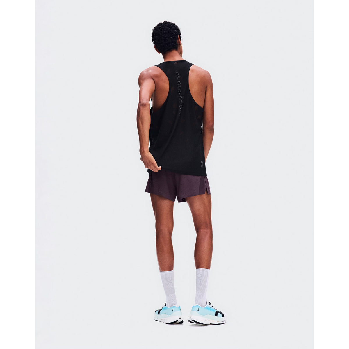 Men's On Zero Tank Breathe Black back full body view on male runner showing functional jacquard construction with signature reflective detailing and On DryTec quick-drying fabric for high-paced running
